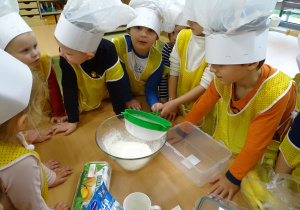 Dzieci przesiewają mąkę